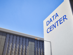 Exterior view of a modern data center building under a clear blue sky